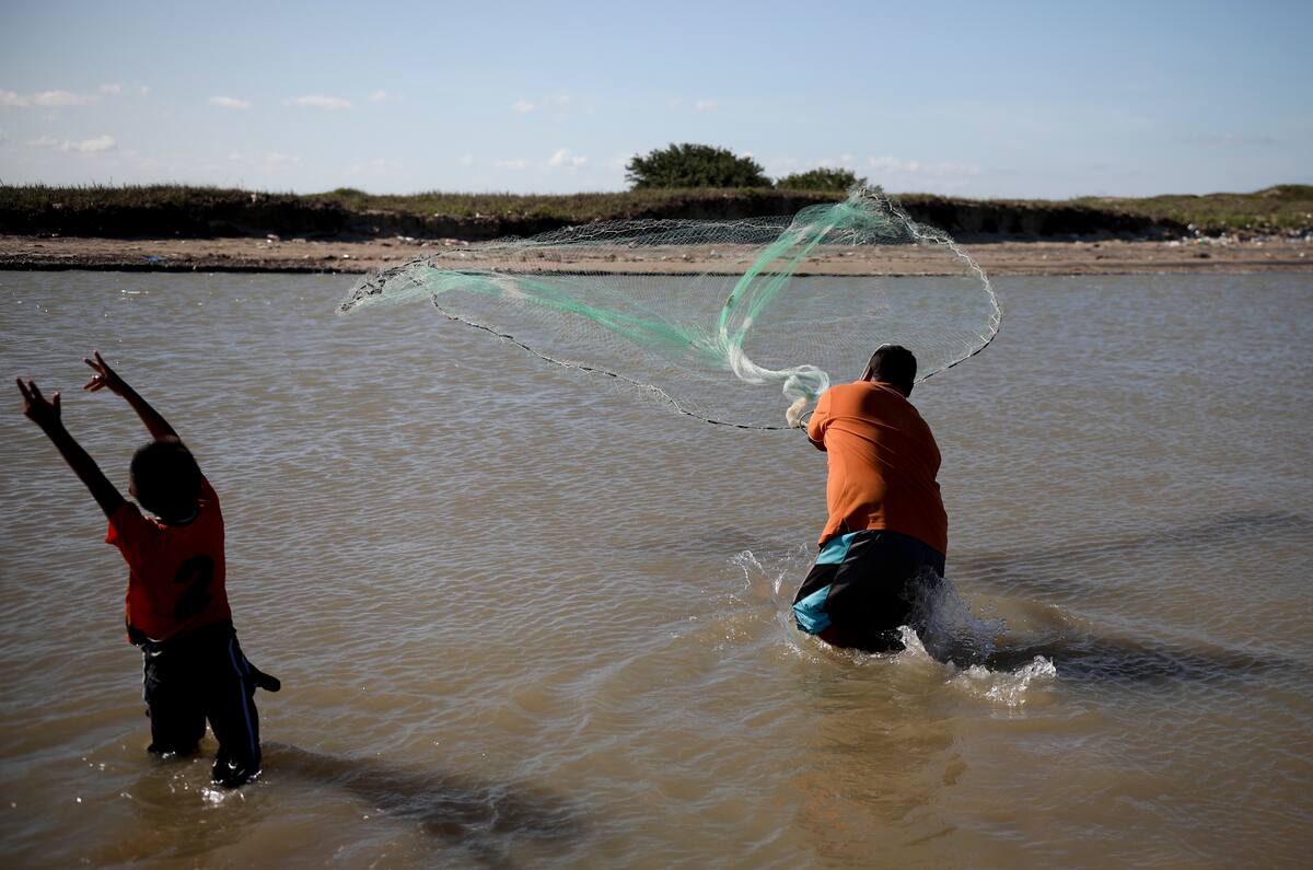 En esta imagen, tomada el 2 de agosto de 2019, turistas locales pescan en las aguas de Playa Bagdad, cerca de la ciudad fronteriza de Matamoros, México. Además de la pesca, el contrabando siempre estuvo presente: antaño plata, durante la ley seca, alcohol, y desde los años 80 marihuana y cocaína. (AP Foto/Emilio Espejel)