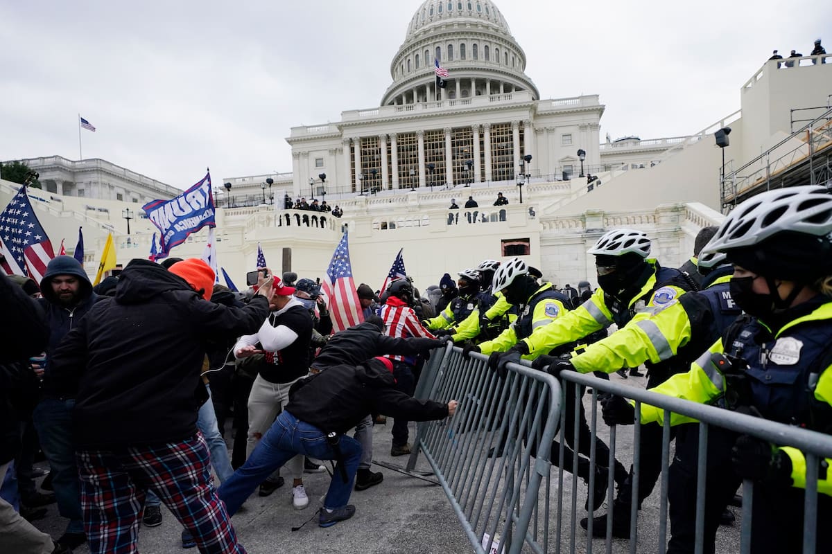 Simpatizantes del presidente Donald Trump tratan de pasar a través de una barrera de la policía, el miércoles 6 de enero de 2021, en el Capitolio, en Washington. (AP Foto/Julio Cortez)
