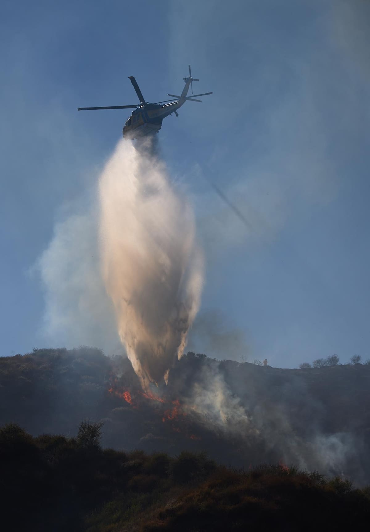 Un helicóptero arroja agua en el incontrolable incendio en Simi Valley, California, este 3 de Julio del 2024. | EFE/EPA/ALLISON DINNER