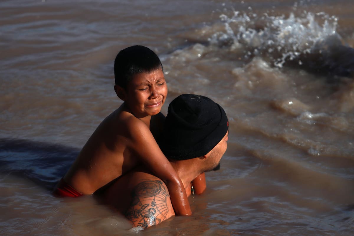 Un migrante con su hijo en la espalda cruza el Río Bravo, en la frontera que divide a México de los Estados Unidos, el 14 de marzo de 2024, en Ciudad Juárez (México). EFE/Luis Torres