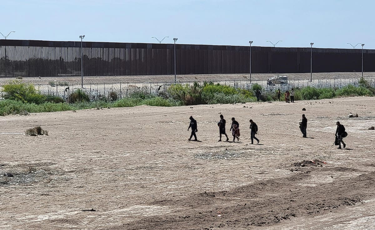 Foto de archivo de migrantes caminando por una orilla de la línea divisoria entre México y EU, en Ciudad Juárez, Chihuahua. | EFE/ Luis Torres